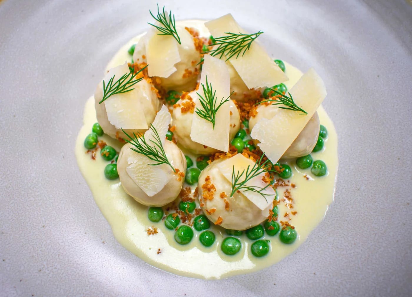 InHaus Cooking plated dish with peas, dill and shaved cheese