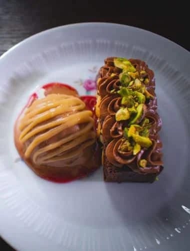 InHaus Cooking plated dessert with sliced fruit and pistachios