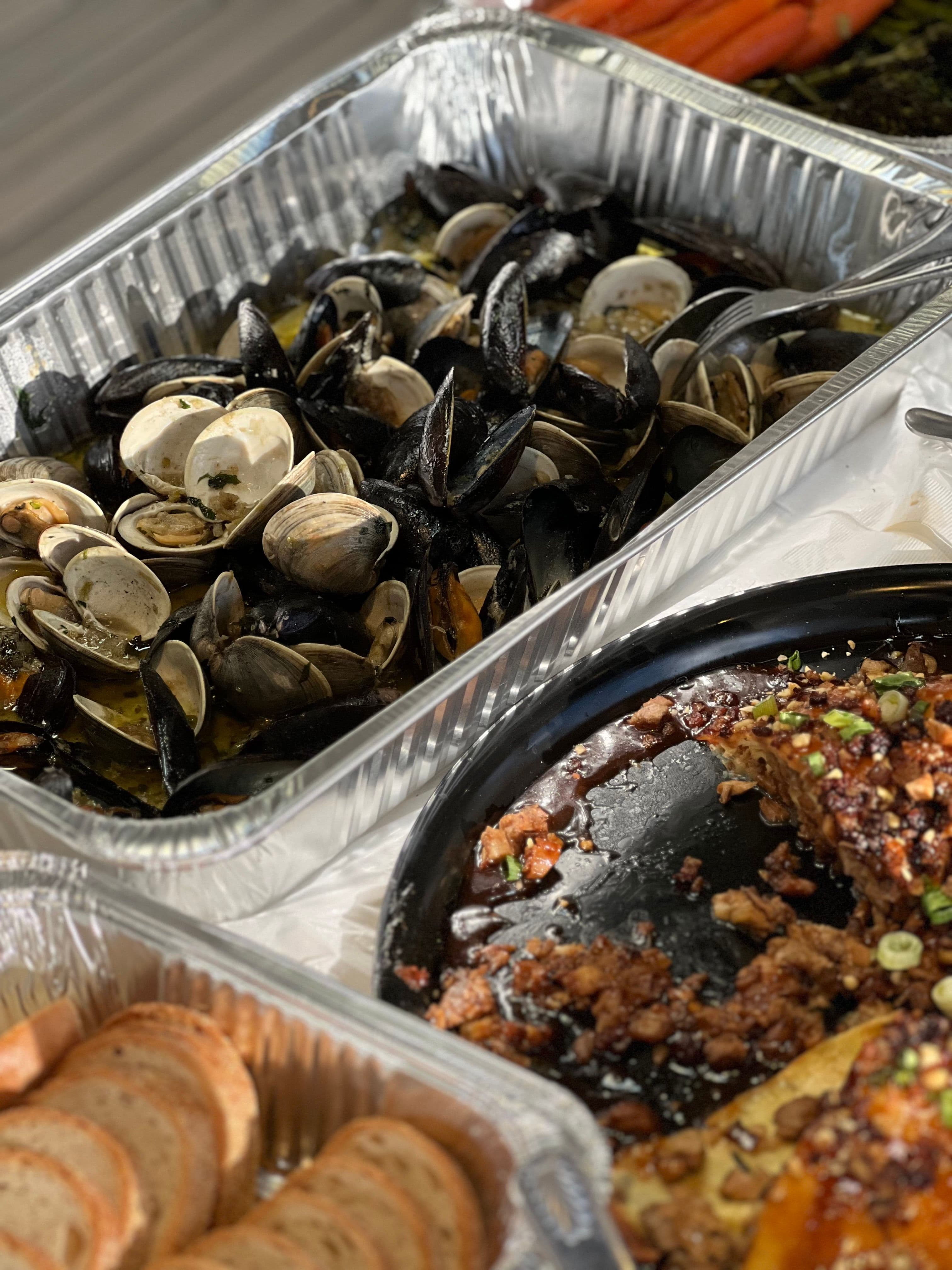 Generous catered table spread with salads, breads and shared dishes